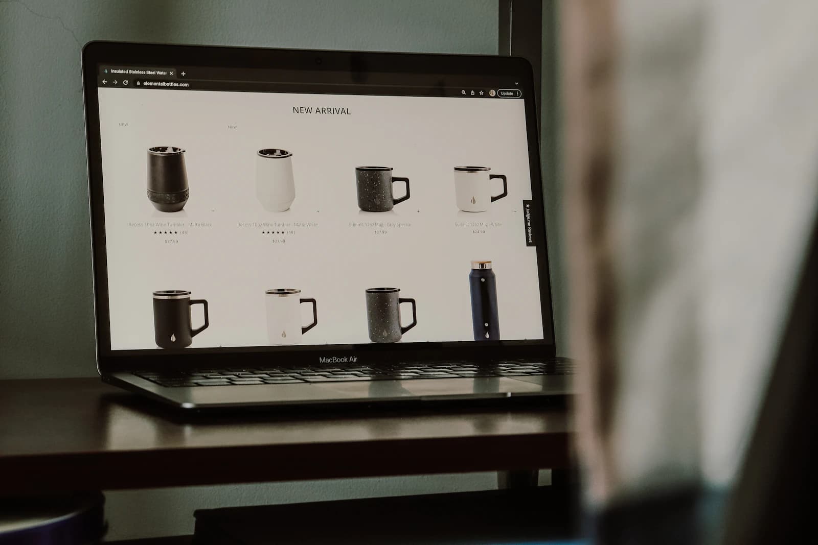 Laptop aperto che mostra una pagina e-commerce con prodotti in vetrina